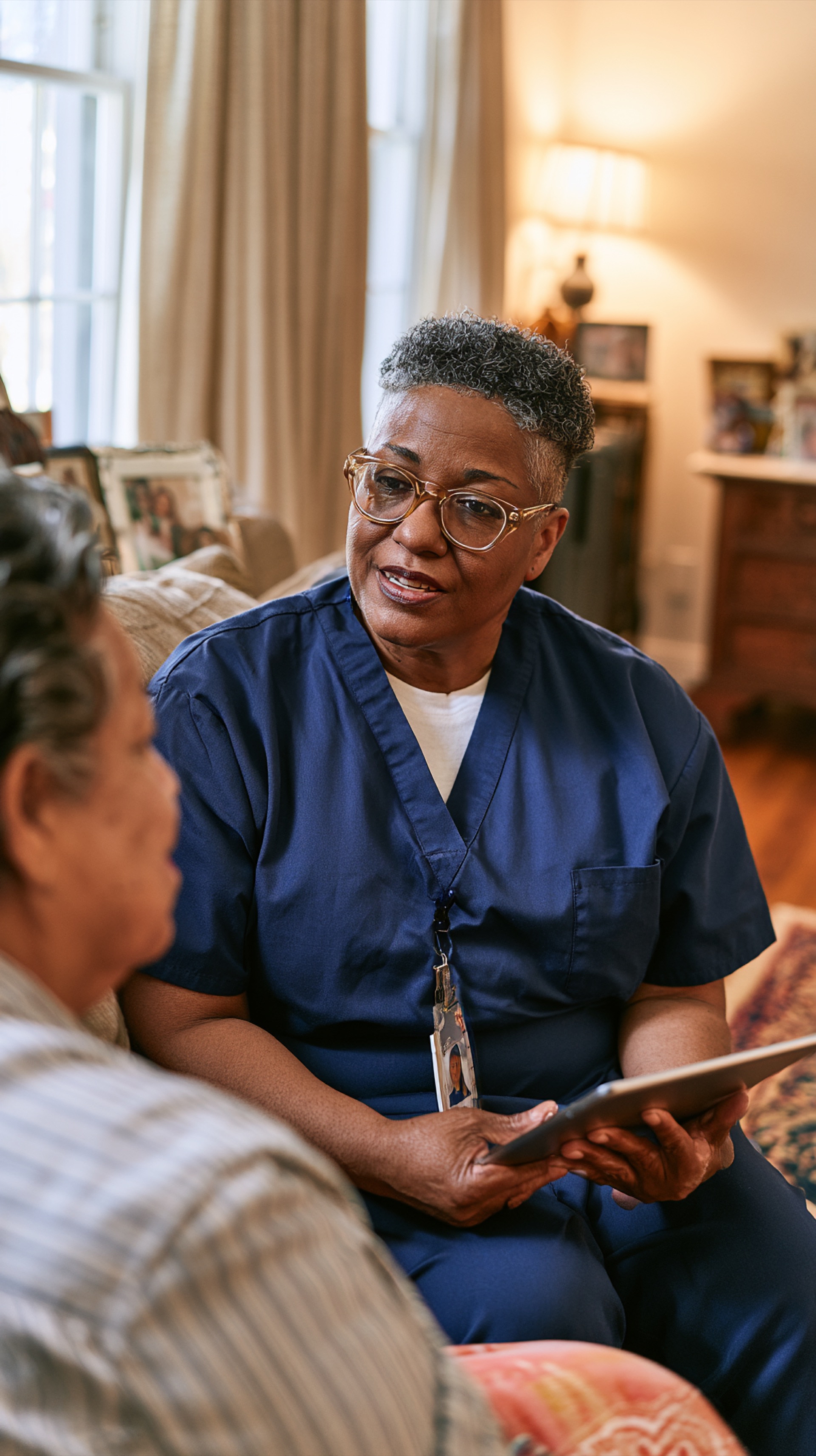 A community health worker listening to a patient at home